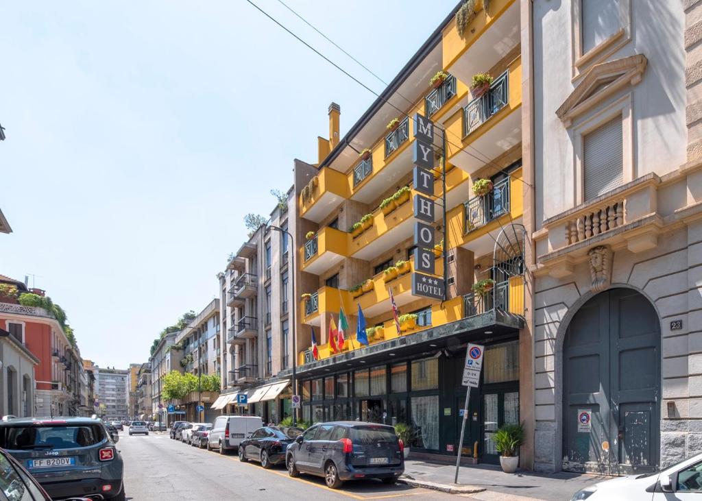 a street with cars parked in front of a building at Hotel Mythos in Milan