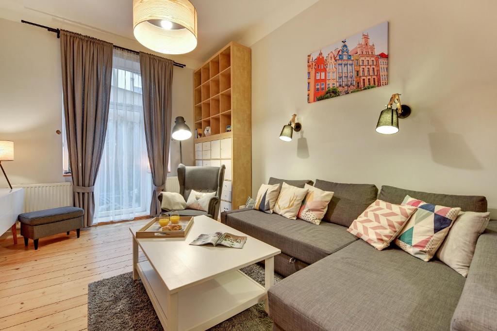 a living room with a couch and a table at Grand Apartments - Monte Cassino Blanco in Sopot