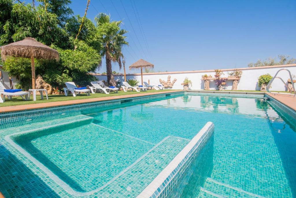 einen Pool mit blauem Wasser in einem Resort in der Unterkunft Cubo's Casa Rural Tirado in Alhaurín el Grande