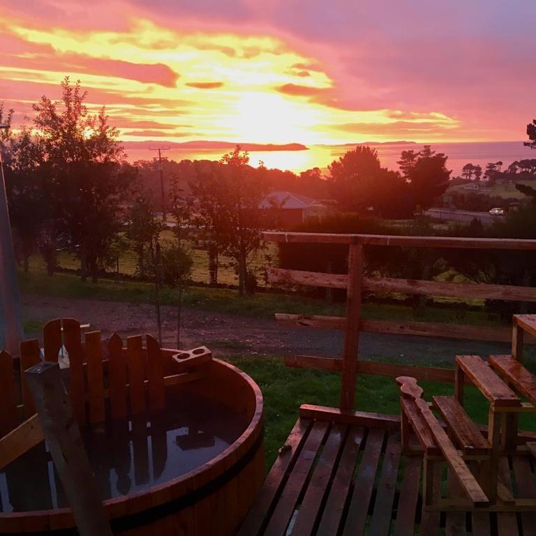 a sunset in a yard with a hot tub at domoschiloe in Ancud