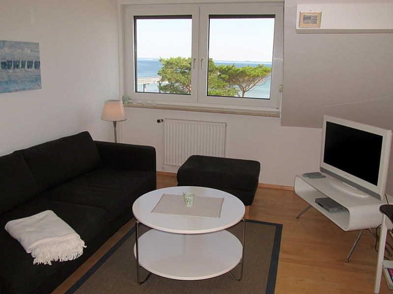 a living room with a couch and a table and a television at Apartmentvermittlung Mehr als Meer - Objekt 28 in Niendorf