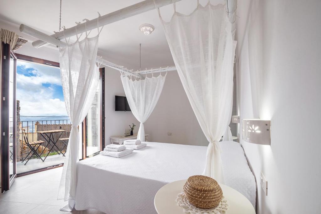 Dormitorio blanco con cama y ventana grande en Elune B&B en Baunei