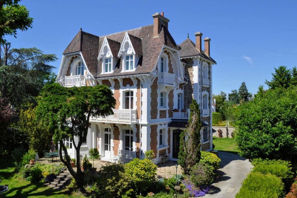 a large white house with a turret at Villa de caractère 8 à 15p, 350 m2 - 15 mn Paris, 10 mn Versailles in La Celle-Saint-Cloud