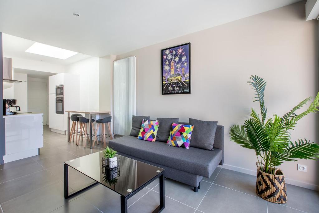 a living room with a couch and a table at Le Temple, Studios & Appartement in Arras