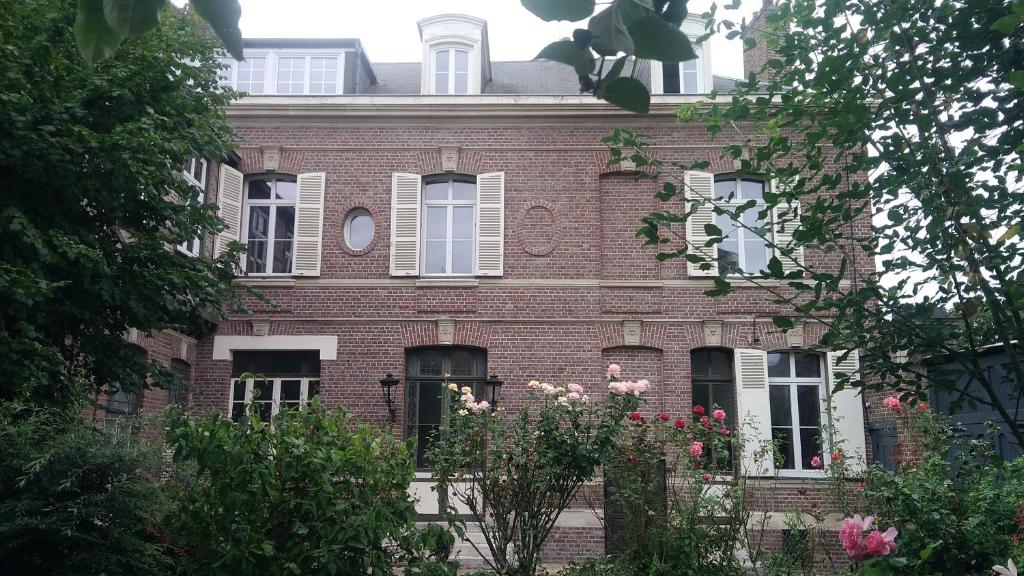 um edifício de tijolos com flores à frente em Jules Verne em Amiens