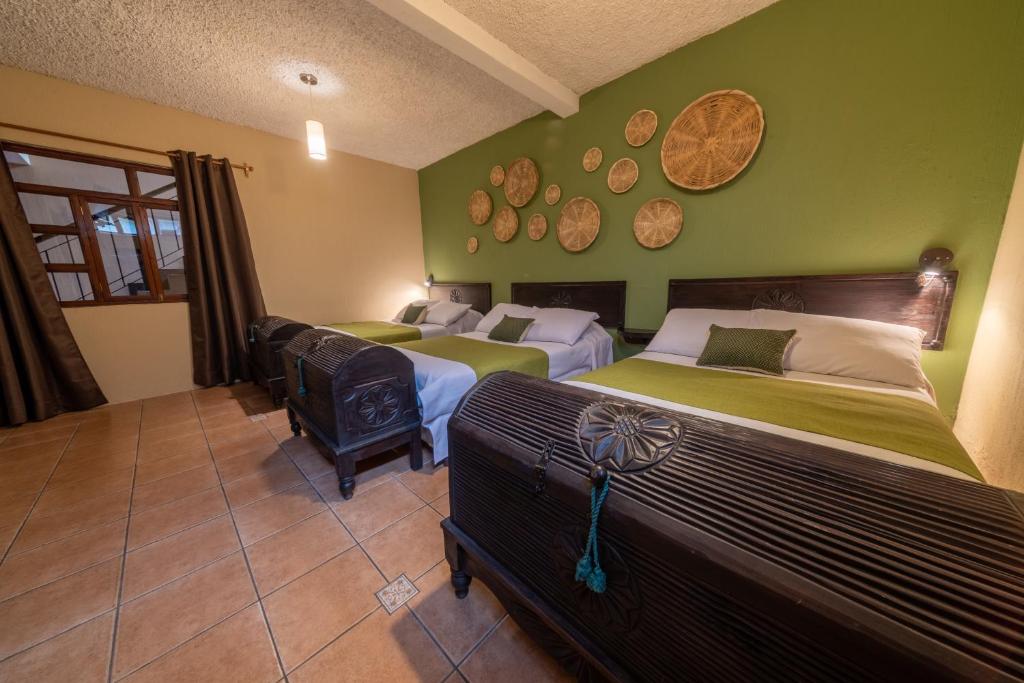 2 camas en una habitación con paredes verdes en 7 orejas en Quetzaltenango