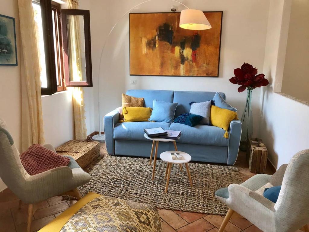 a living room with a blue couch and two chairs at Place San Pantaléo : jolie maison sarde authentique in San Pantaleo