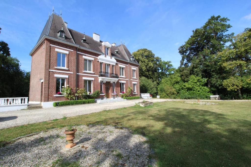 een groot rood bakstenen huis met een grasveld bij Bed & Breakfast au Château de Martinsart in Mesnil-Martinsart