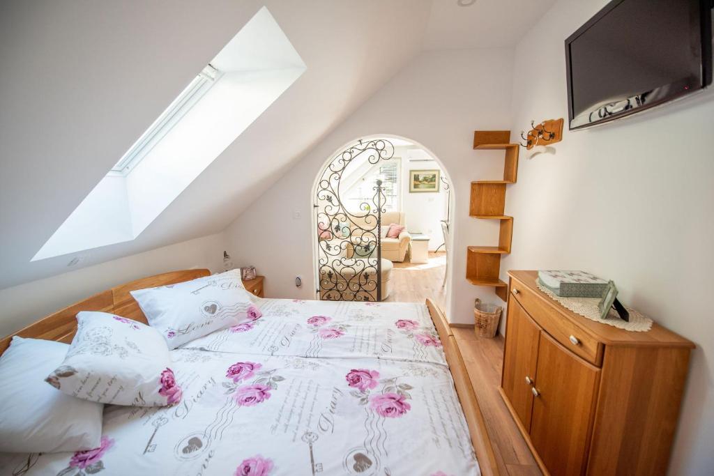 una camera da letto con un letto con fiori rosa di Apartmaji Urška a Laško