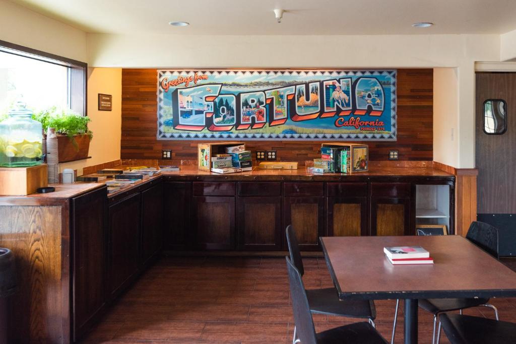 a restaurant with a bar with tables and chairs at The Redwood Riverwalk, a boutique hotel in Fortuna