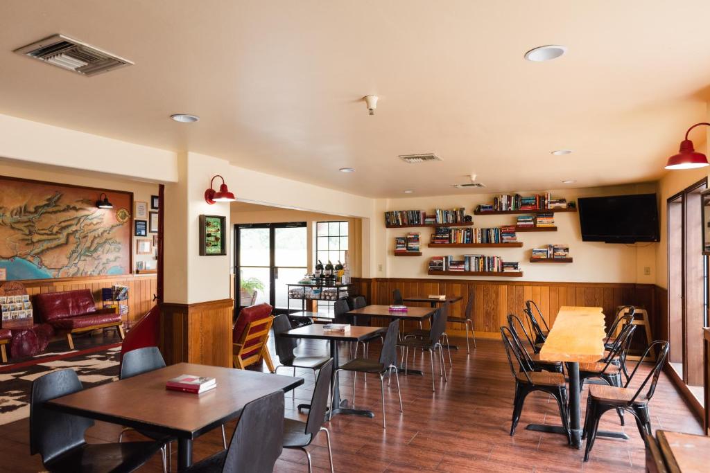 a restaurant with tables and chairs and a tv at The Redwood Riverwalk, a boutique hotel in Fortuna