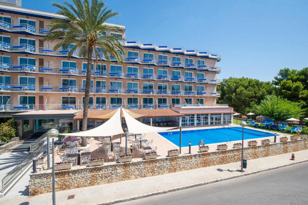 un hotel con piscina frente a un edificio en NURA Boreal, en Playa de Palma