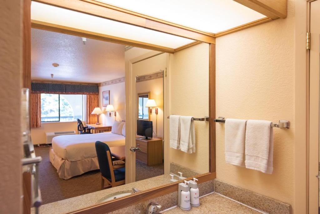 a hotel room with a bed and a mirror at The Redwood Riverwalk, a boutique hotel in Fortuna