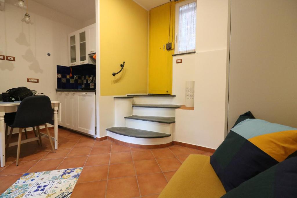 a living room with a yellow cabinet and stairs at Giallo Napoli in Naples
