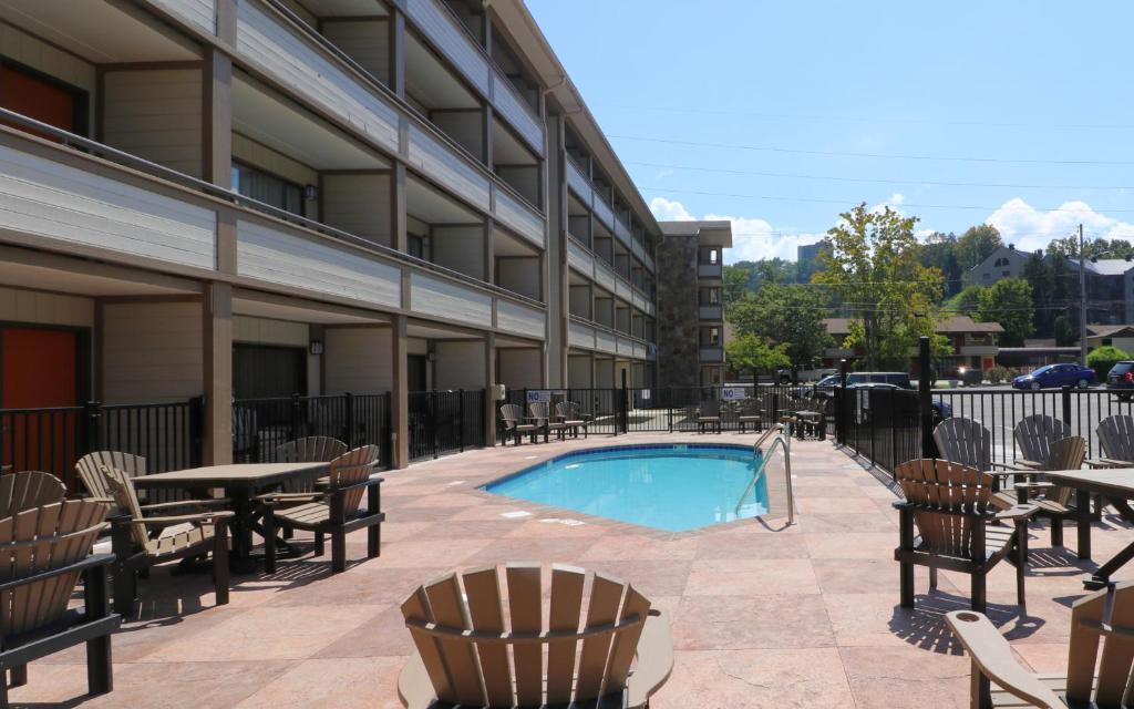 a patio with tables and chairs and a swimming pool at Howard Johnson by Wyndham Downtown Gatlinburg in Gatlinburg