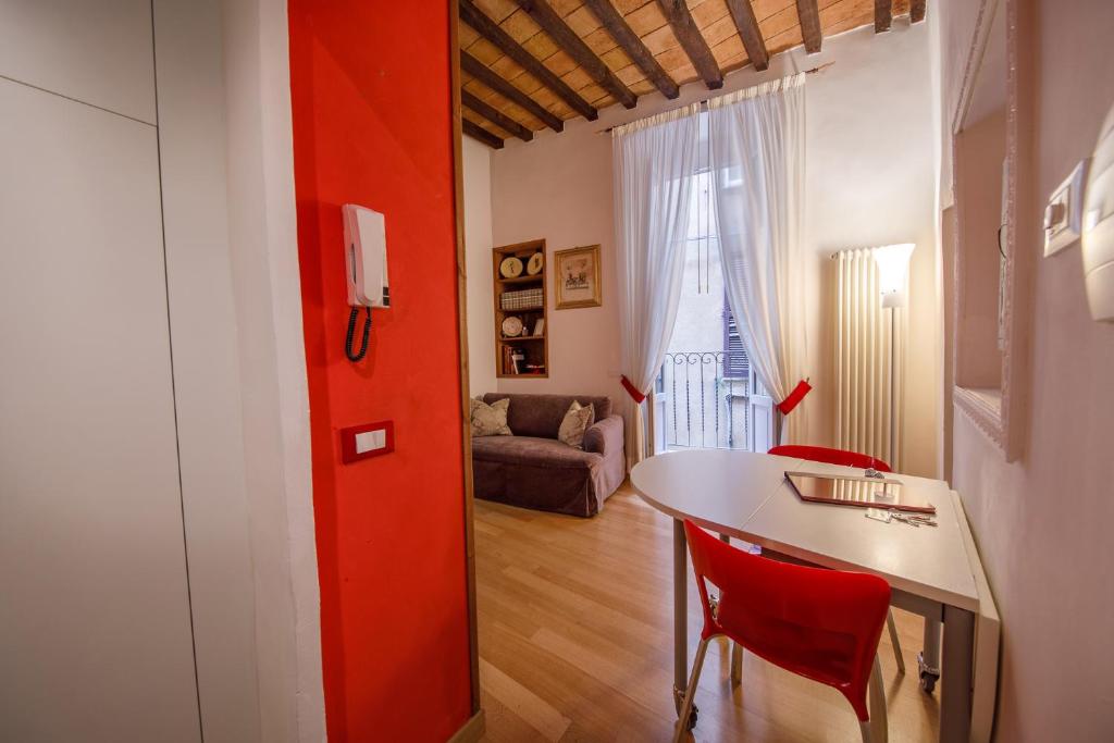 ペルージャにあるLuna 14 - Charming Suiteの赤い壁の客室で、テーブルと椅子が備わります。