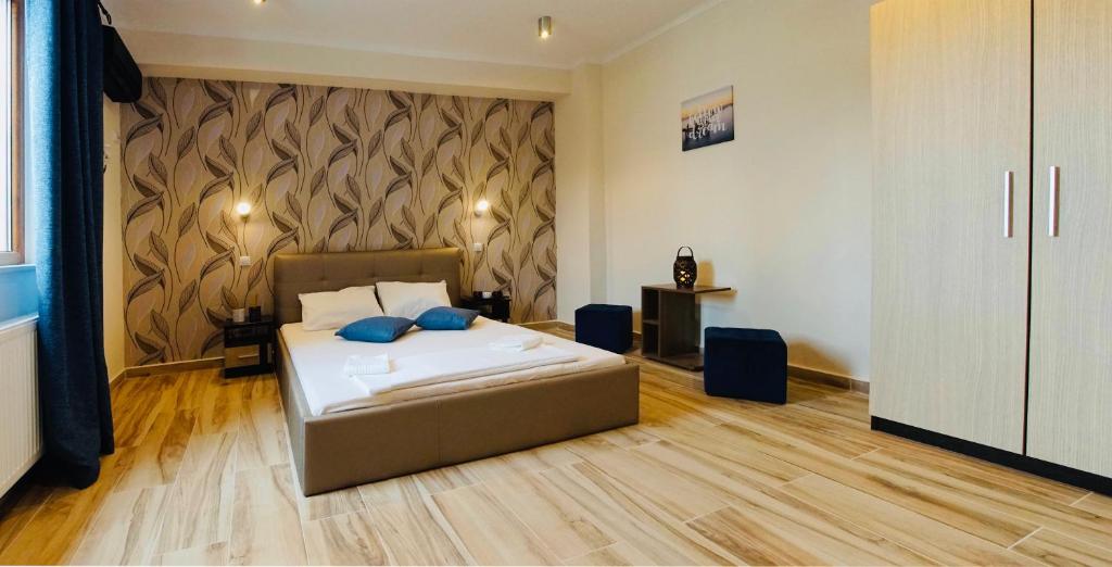 ein Schlafzimmer mit einem Bett mit blauen Kissen darauf in der Unterkunft Byzanthin Hostel in Bukarest