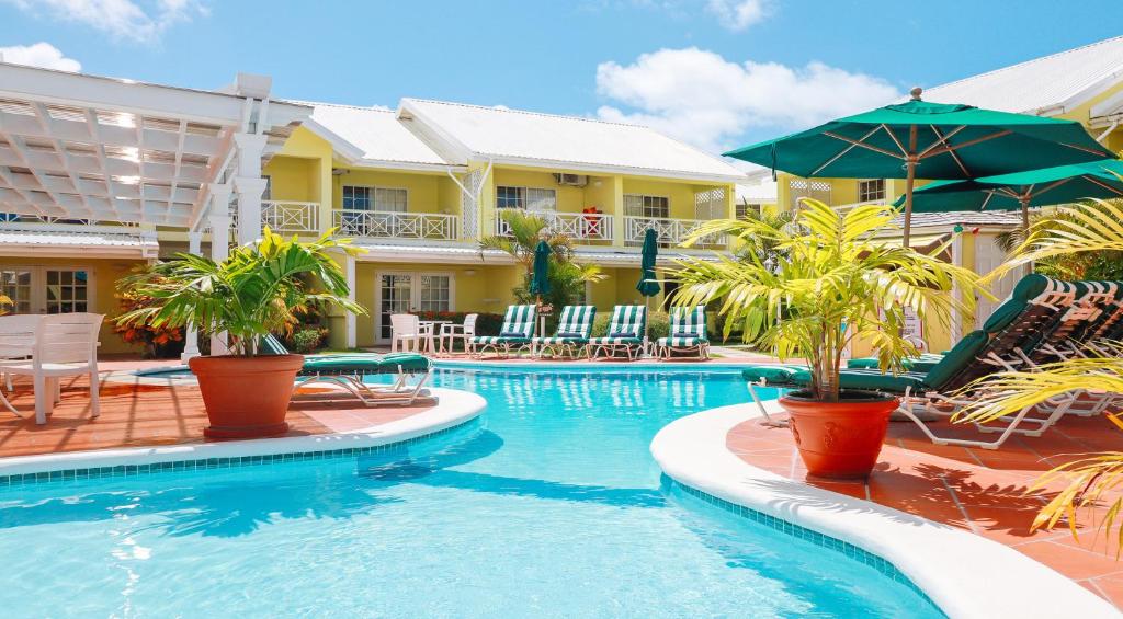 a pool at a resort with chairs and umbrellas at Bay Gardens Hotel in Gros Islet