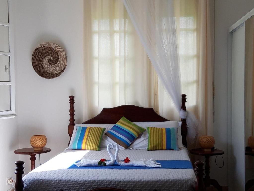 a bedroom with a bed with some pillows at Ti Cajou in Baie-Mahault