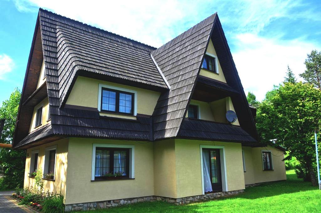 a yellow house with a black roof at Dom u Małgosi in Witów