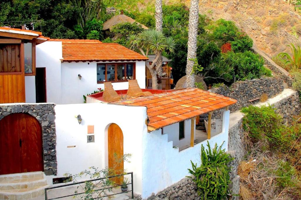 una pequeña casa blanca con techo naranja en Villa with Ocean View, en Agulo