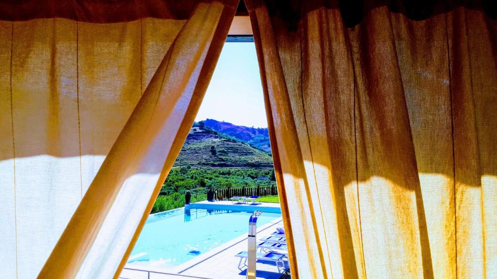 een raam met uitzicht op een zwembad bij Mauro Home Bed and Relax in Linguaglossa