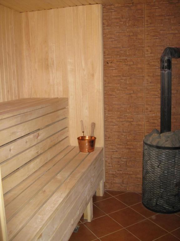 una panca di legno in una stanza con un bidone della spazzatura di Jūra a Ventspils