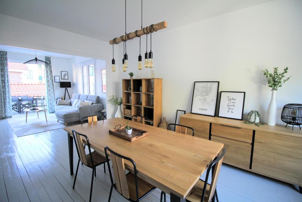 een woonkamer met een houten tafel en stoelen bij Villa Centre ville in Arcachon