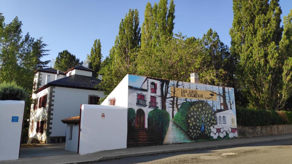 un edificio con un mural en el costado en Casa Jardín El Colmenar, en Las Navas del Marqués