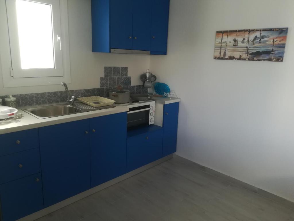 a kitchen with blue cabinets and a sink at Sofia's view in Amaliapoli