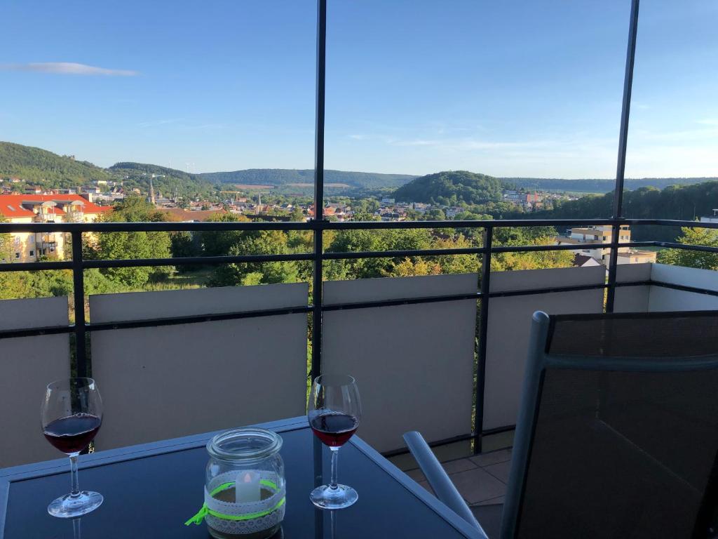 two glasses of wine on a table with a view at Apartment AusZeit in Bad Kissingen
