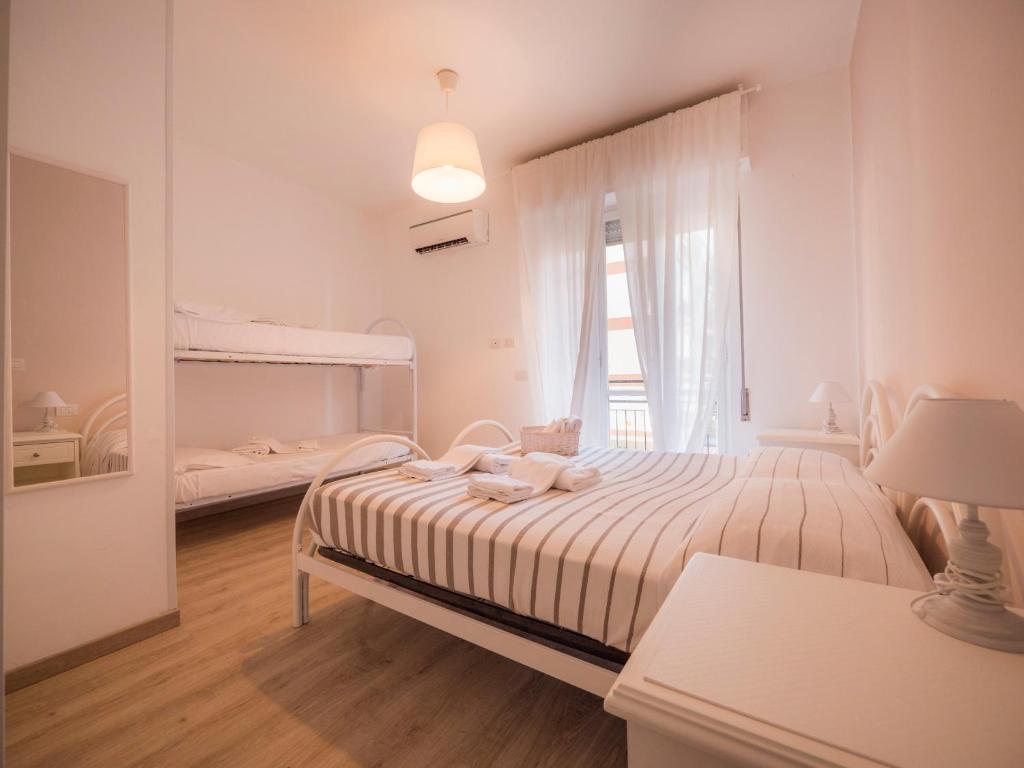 una camera da letto bianca con un letto e una finestra di Hotel Continental a Pietra Ligure