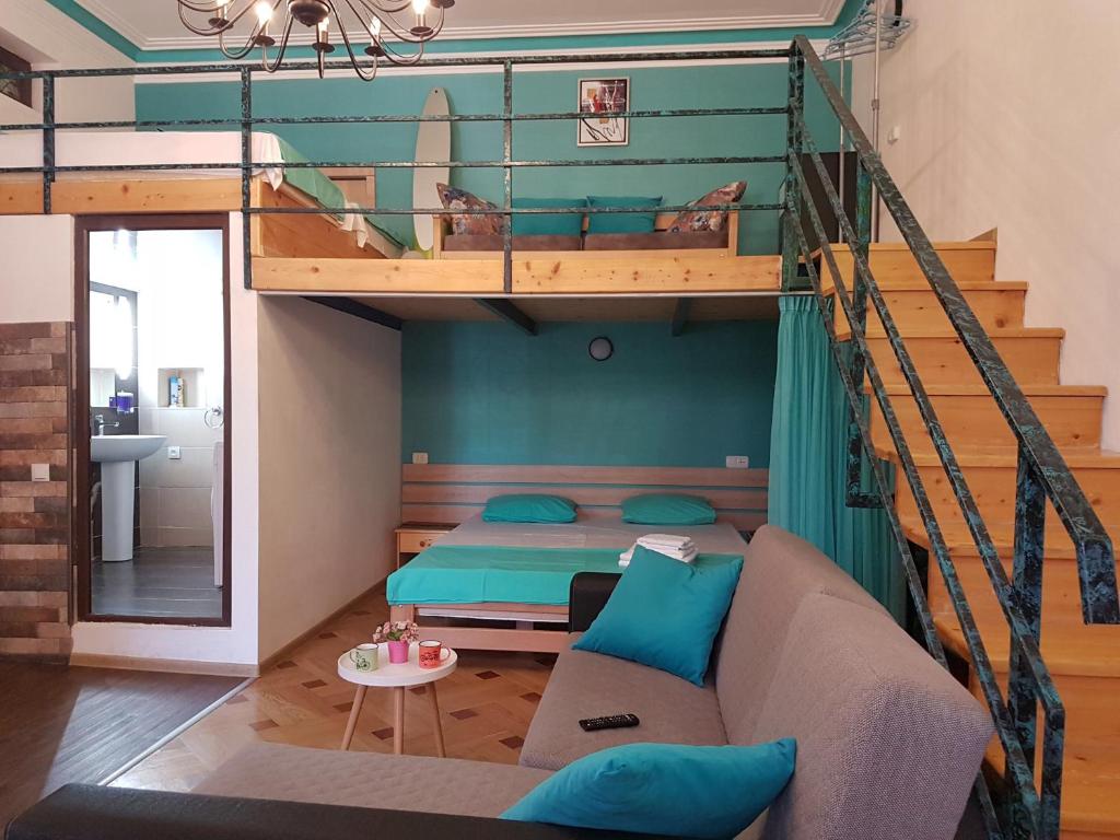 a bedroom with a bunk bed and a couch in a room at Comfortable Flat in Central Tbilisi in Tbilisi City