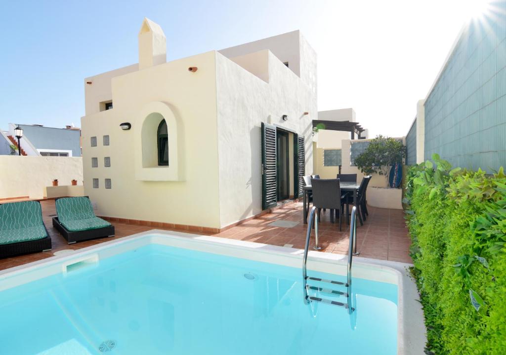 a swimming pool in front of a house at Villa Olympia Lovely, Close to Town and Beaches with Private Pool & Fast WiFi in Corralejo