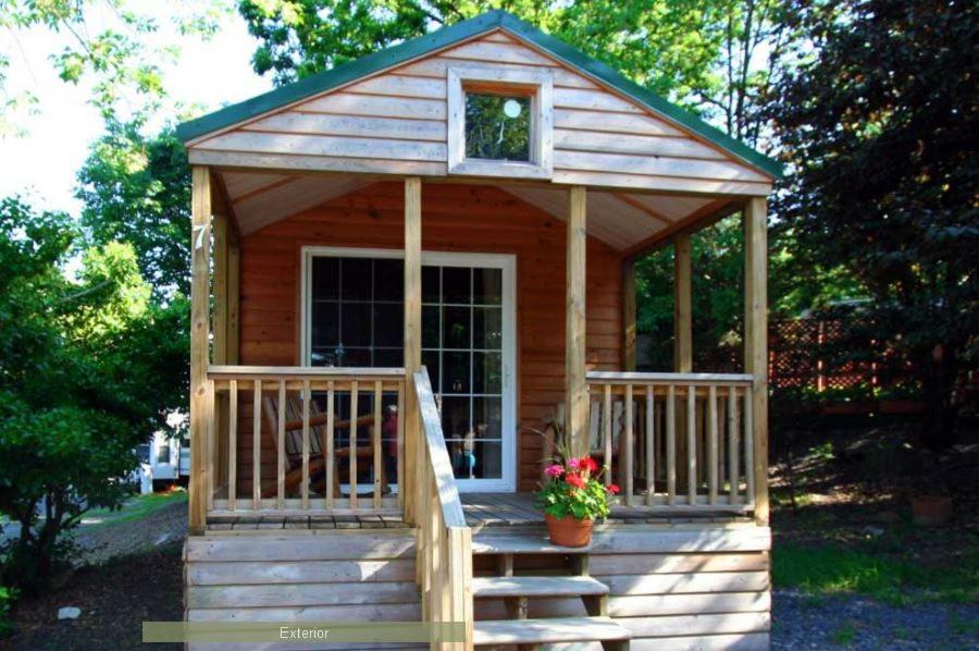 a small wooden cabin with a porch and stairs at Round Top Premiere Cottage 6 in Gettysburg