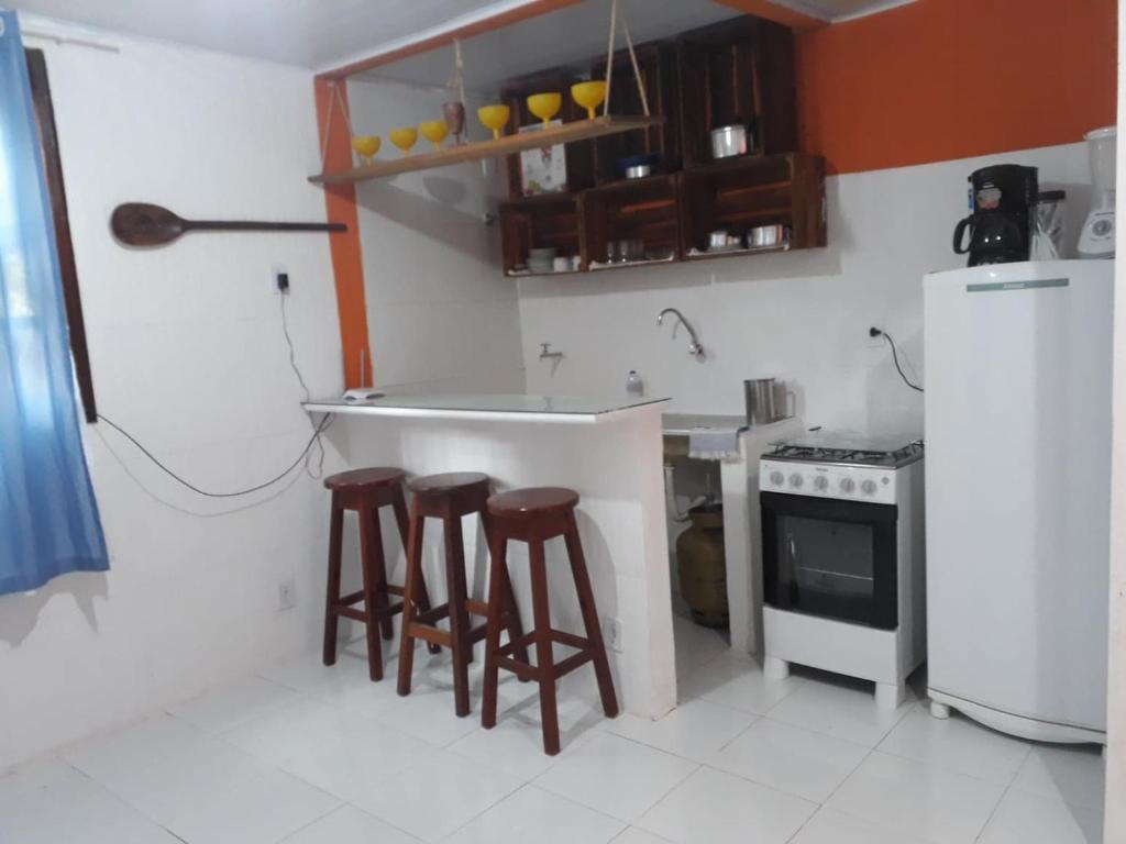 una cucina con 2 sgabelli da bar e un frigorifero di Ita do Mar a Morro de São Paulo