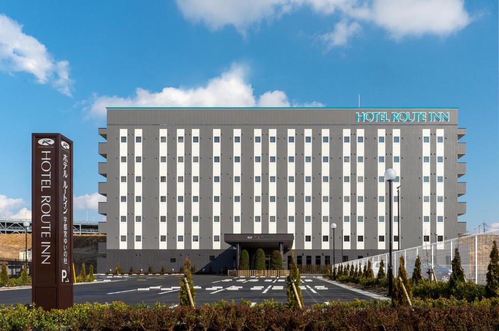 a hotel with a sign in front of a building at Hotel Route-inn Utsunomiya Yuinomori -Lightline Yuinomori Nishi- in Utsunomiya