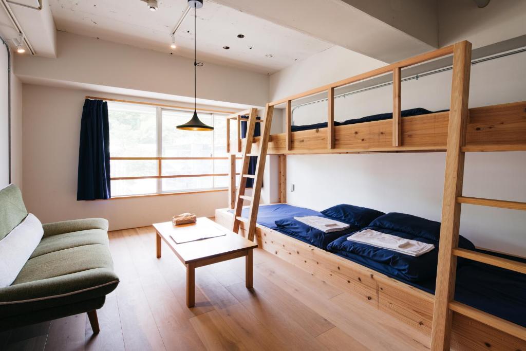 a living room with a bunk bed and a couch at Uzu House in Shimonoseki