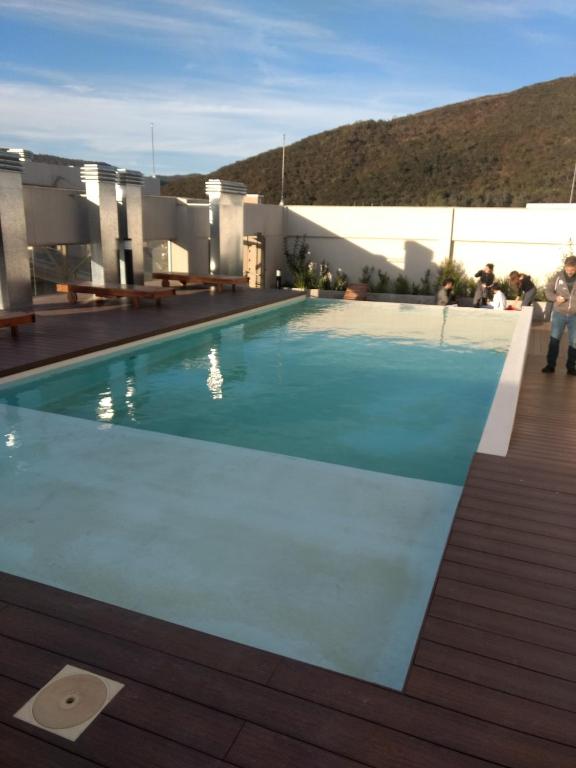 a swimming pool on top of a house with a mountain at Luxury Suite Salta in Salta