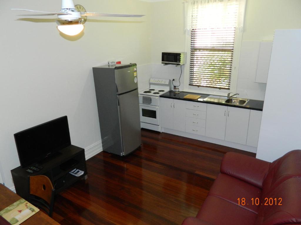 a kitchen with a stainless steel refrigerator and a television at Champion Bay Apartments in Geraldton