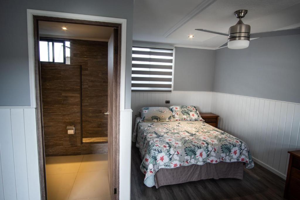 a bedroom with a bed and a sliding glass door at Inaki Uhi Hotel in Hanga Roa