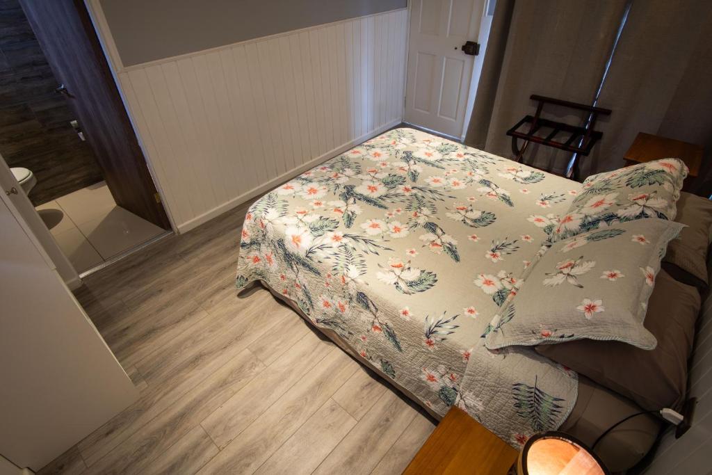 a bed in a room with a blanket on it at Inaki Uhi Hotel in Hanga Roa