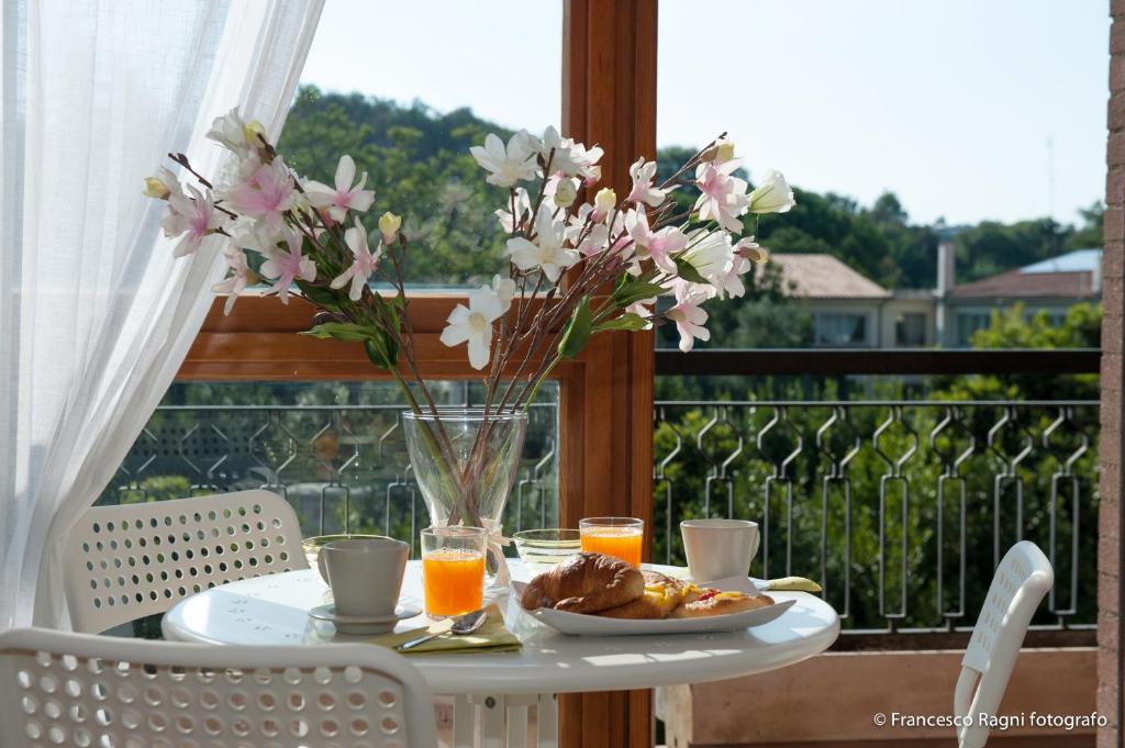 a table with a plate of food and flowers on a balcony at B&B St. Peter's Suites in Rome
