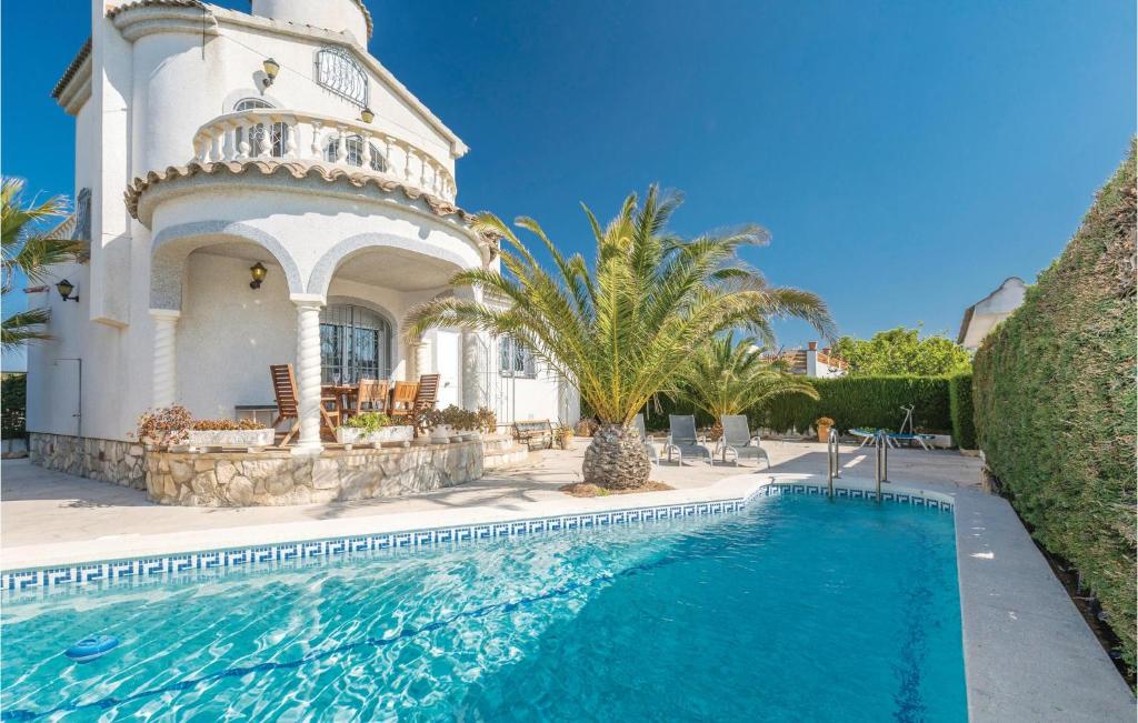 uma casa com piscina em frente a um edifício em Amazing Home In Lametlla De Mar With Swimming Pool em Les tres Cales