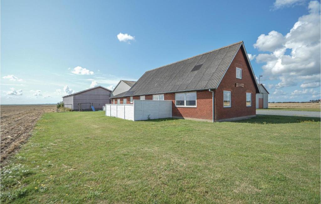 a red brick house on a large grass field at Holiday Home Vesterende Bredebro Ix in Ballum