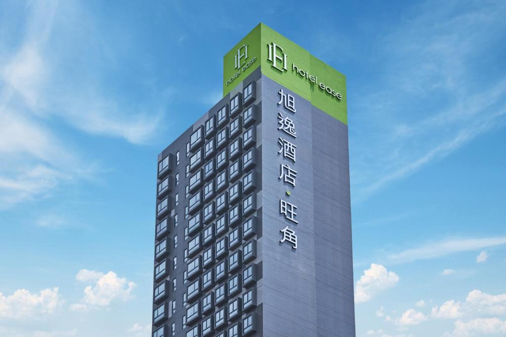 a tall building with a sign on top of it at Hotel Ease Mong Kok in Hong Kong