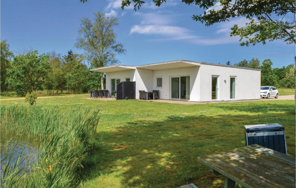 a white house with a picnic table in a yard at Holiday Home Dyrefolden Ringkøbing Vi in Hee