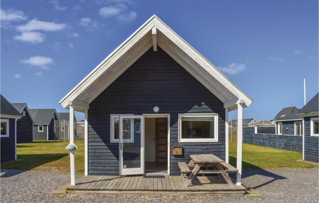 una pequeña casa azul con una mesa de picnic delante de ella en Hytte 26, en Thyborøn