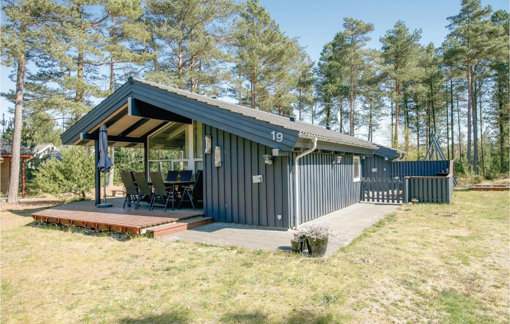 a blue shed with a table and chairs in a field at Holiday Home Odde Naturpark Vi in Helberskov