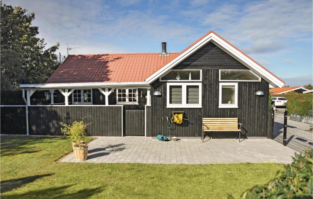 una casa negra con un banco y una valla en Cozy Home In Nyborg With Kitchen en Nyborg